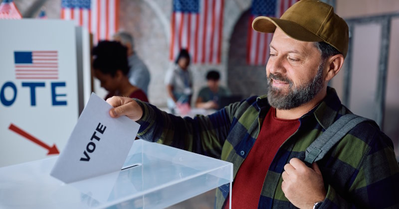 Smiling mature man voting during elections in usa